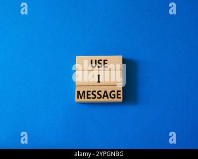 Verwenden Sie das i-Nachrichtensymbol. Konzeptwort Verwenden Sie I-Botschaft auf Holzblöcken. Wunderschöner blauer Hintergrund. Business and Use i Message Konzept. Kopierbereich. Stockfoto
