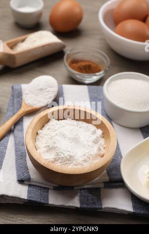 Backpulver in der Schüssel und andere Produkte auf Holztisch Stockfoto
