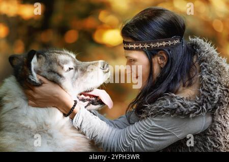 Porträt einer jungen hübschen Frau mit einem Alaska Malamute Hund im Wald vor dem Hintergrund der Natur Stockfoto