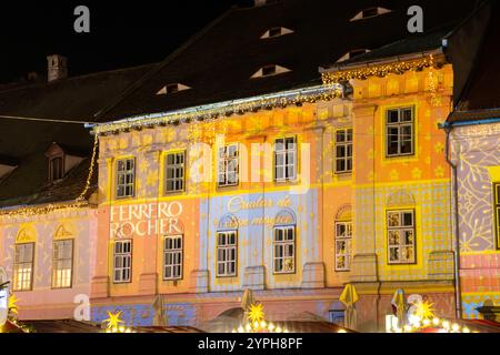 Ferrero Rocher Werbespot auf ein Gebäude projiziert. Weihnachtsbeleuchtung in einem Gebäude auf dem Weihnachtsmarkt in Sibiu, Rumänien Stockfoto