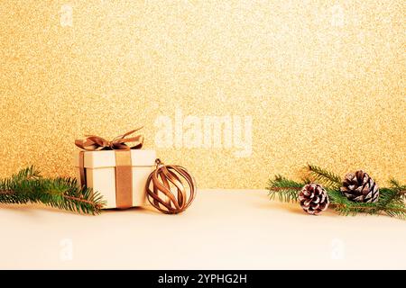 Weihnachtsszene mit Tannenzweigen, Geschenkboxen auf glitzerndem Goldhintergrund. Kopierbereich. Stockfoto