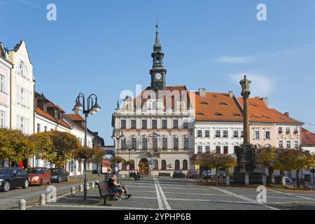 Rathausplatz mit Uhrenturm und historischen Gebäuden unter blauem Himmel, Rathaus und Pestsäulensäule der Heiligen Dreifaltigkeit, ceska Lipa, Bohe Stockfoto