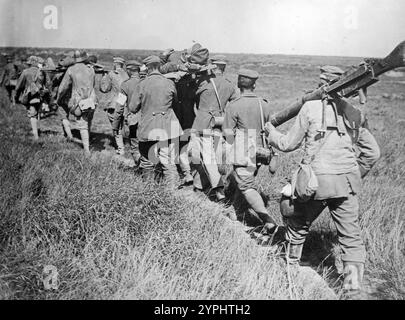 Deutsche Gefangene brachten verwundete Soldaten und gefangengenommene Maschinengewehre während der dritten Schlacht bei Albert in der Nähe von Courcelles, Frankreich, 21. August 1918 während des Ersten Weltkriegs Stockfoto