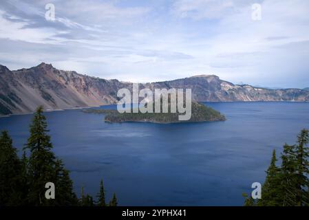 Blick auf den majestätischen kristallklaren blauen See mit einer massiven Insel aus hoher Höhe, mit Kiefern auf dem nahegelegenen Kamm und einer dramatischen Wolkenlandschaft. Stockfoto