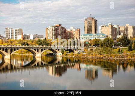 Eine Stadt mit einem Fluss und einer Brücke darüber. Die Brücke spiegelt sich im Wasser Stockfoto