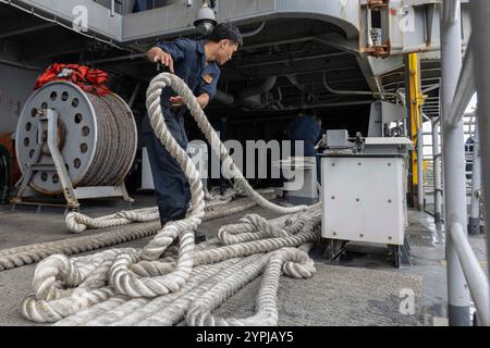 241127-N-BE753-1092 PORT KLANG, MALAYSIA (27. November 2024) Boatswain’s Mate Seaman John Corpus aus Apopka, Fla., fährt auf dem Fantail des Flugzeugträgers USS Abraham Lincoln (CVN72) um die Linie. Abraham Lincoln, Flaggschiff der Carrier Strike Group Three, ist derzeit im Hafen von Port Klang, Malaysia, für einen geplanten Hafenbesuch an der Pier-Seite verankert. (Foto der US Navy von Seaman Glory Anderson, Spezialist für Massenkommunikation) Stockfoto