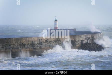 Große Wellen treffen auf Wellenbrecher und Leuchtturm Stockfoto