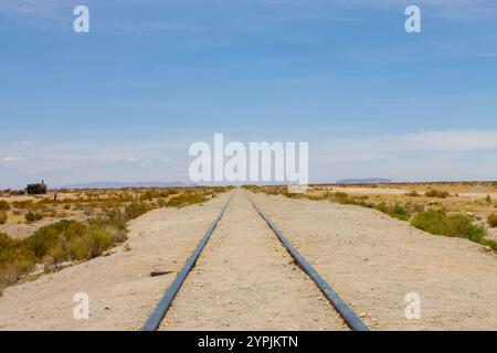 Ein altes, verwittertes Bahngleis, das in die weite Wüste auf dem Bahnfriedhof (Cementerio de Trenes) in der Nähe von Uyuni in Bolivien führt Stockfoto