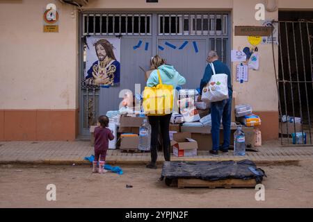 Valencia, Spanien. November 2024 30. Eine Familie sammelt an einem Stand in der Stadt Paiporta, einer Stadt im Süden Valencias, die Grundbedürfnisse sammelt. Am 29. November war ein Monat vergangen, seit Ende Oktober die isolierte Depression auf hohem Niveau (DANA) die Städte des Gebiets L´Horta Sud südlich der spanischen Stadt Valencia betraf und die nicht nur Millionen an wirtschaftlichen Schäden verursachte, sondern auch mehr als 200 Menschen das Leben forderte. (Foto: David Canales/SOPA Images/SIPA USA) Credit: SIPA USA/Alamy Live News Stockfoto