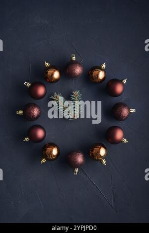 Uhr aus weihnachtlichem Dekor und Tannenbäumen auf dunklem Hintergrund Stockfoto