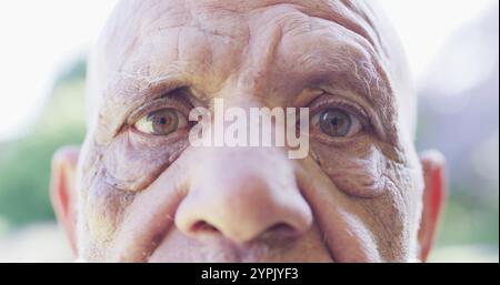 Porträt der Nahaufnahme eines älteren birassischen Mannes, der im Garten Augen weit öffnet Stockfoto