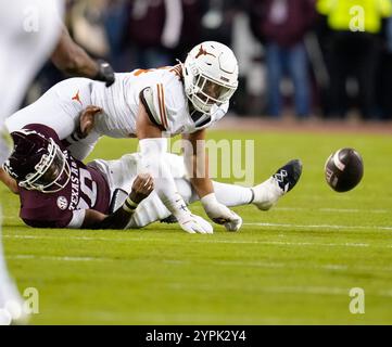 College Station, Texas, USA. November 2024 30. Der Texas Linebacker Trey Moore (8) sieht den Ball, nachdem er im vierten Quartal des College-Footballspiels zwischen den Texas A&M Aggies und den Texas Longhorns am 30. November 2024 in College Station, Texas einen Fumble auf einen Sack von Texas A&M Quarterback Marcel Reed (10) gedrängt hat. Texas gewann mit 17:7. (Kreditbild: © Scott Coleman/ZUMA Press Wire) NUR REDAKTIONELLE VERWENDUNG! Nicht für kommerzielle ZWECKE! Quelle: ZUMA Press, Inc./Alamy Live News Stockfoto