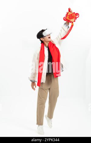 Junger asiatischer Mann, der eine VR-Brille trägt und FU hält Stockfoto
