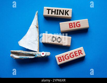 Denken Sie an großes, größeres Symbol. Holzblöcke mit Worten denken, Big machen größer. Schöner blauer Hintergrund mit Boot. Business und Think Big können größer werden. Kopieren Stockfoto