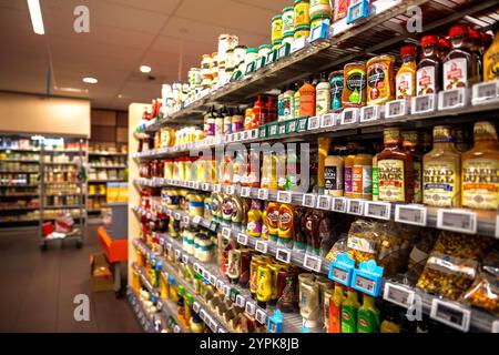 Haarlem, Niederlande - 30. August 2024: Verschiedene Mayonnaise, Ketchup und andere Saucen werden in den Regalen eines niederländischen Supermarktes ordentlich ausgestellt und zeigen Vielfalt und Ordnung in einem leeren Laden Stockfoto