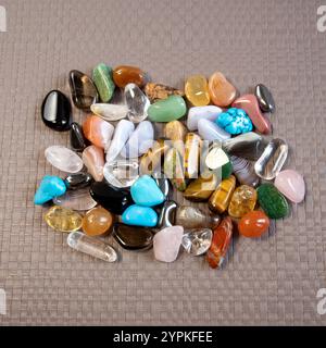 Sammlung von Halbedelsteinen auf hellbraunem, strukturiertem Hintergrund von oben Stockfoto