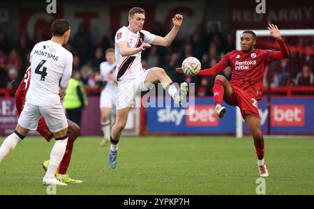 Bradley Ibrahim (R) von Crawley Town während des Spiels der 2. Runde des FA Cup zwischen Crawley Town und Lincoln City im Broadfield Stadium in Crawley. Stockfoto