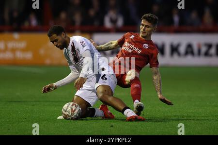 Gavan Holohan von Crawley Town und Ethan Erhahon von Lincoln City beim Spiel der 2. Runde des FA Cup zwischen Crawley Town und Lincoln City im Broadfield Stadium in Crawley. Stockfoto