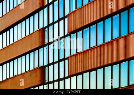 Moderne Gebäudefassade mit vertikalen Metallpaneelen und reflektierenden Glasfenstern Stockfoto