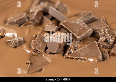 Schokoladenstücke in geschmolzener Milchschokolade. Stockfoto