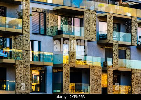 Luxuriöse Fassade des Apartmentgebäudes mit komplexen Goldtäfelungen und Glasbalkonen Stockfoto