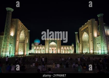 Samarkand, Usbekistan - 6. Juli 2024: Registan bei Nacht beleuchtet von Lichtern und Touristen, die auf die Show warten Stockfoto