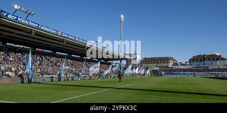 Die Fahnenschwenker und Stadionsprecher Sebastian Schaech (TSV 1860 München) vor der Stehhalle vor Spielbeginn, im Hintergrund rechts der Gaestblock mit den rund 1500 mitgereisten Fans von der Ostsee. GER, TSV 1860 München gegen den FC Hansa Rostock, Fussball, 3. Bundesliga, 16. Spieltag, Saison 2024/2025, 30.11.2024. (DIE DFL-DFB-VORSCHRIFTEN VERBIETEN DIE VERWENDUNG VON FOTOS ALS BILDSEQUENZEN UND/ODER QUASI-VIDEO). Foto: Eibner-Pressefoto/Heike Feiner Stockfoto