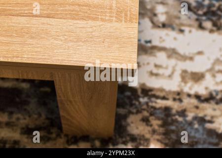 Konzeptaufnahme des Teils des Holztisches auf dem Teppich Stockfoto