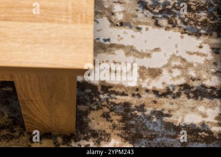 Konzeptaufnahme des Teils des Holztisches auf dem Teppich Stockfoto