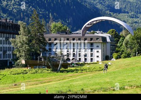 Tandem-Gleitschirmfliegen auf einer Wiese in der Nähe des Zentrums der Alpenstadt im Sommer, Chamonix, Haute Savoy, Auvergne Rhone Alpes, Frankreich Stockfoto