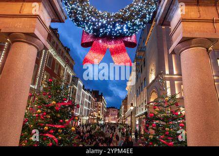 Covent Garden, London, England - 27. November 2024: Zauberhafte Weihnachtsszene mit leuchtenden Bäumen, festlichen Kränzen, glitzernden Lichtern und einem geschäftigen Treiben Stockfoto