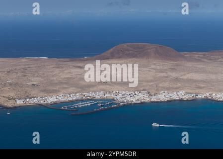 Blick auf die Insel La Graciosa auf den Kanarischen Inseln und die Hauptstadt Caleto Del Sebo mit der Fähre in Richtung Hafen. Stockfoto