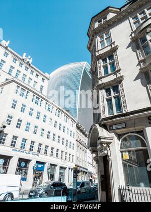 Blick auf das moderne Walkie Talkie Wolkenkratzer inmitten klassischer architektonischer Fassaden in London unter einem hellblauen Himmel Stockfoto