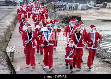 Brixham, Großbritannien, 1. Dezember 2024. 300 Santas nehmen 2024 am Brixham Seaside Santa Run Teil und sammeln Spenden für den Shoalstone Pool in Brixham, devon, Großbritannien. Quelle: Mark Passmore/ Alamy Live News Stockfoto