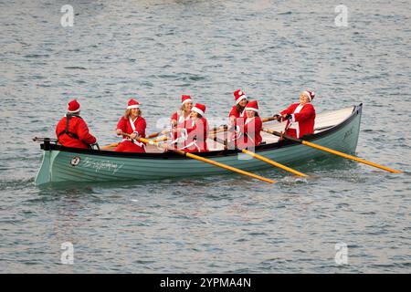Brixham, Großbritannien, 1. Dezember 2024. 300 Santas nehmen 2024 am Brixham Seaside Santa Run Teil und sammeln Spenden für den Shoalstone Pool in Brixham, devon, Großbritannien. Abgebildet sind weibliche rudersantas, die sich am Spaß beteiligen! Quelle: Mark Passmore/ Alamy Live News Stockfoto