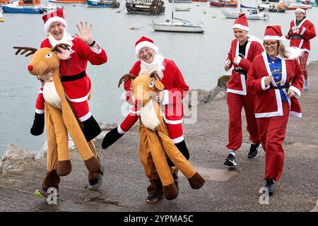 Brixham, Großbritannien, 1. Dezember 2024. 300 Santas nehmen 2024 am Brixham Seaside Santa Run Teil und sammeln Spenden für den Shoalstone Pool in Brixham, devon, Großbritannien. Quelle: Mark Passmore/ Alamy Live News Stockfoto