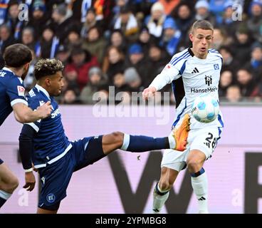 1. Dezember 2024, Baden-Württemberg, Karlsruhe: Fußball: Bundesliga 2, Karlsruher SC - Hamburger SV, Spieltag 14, BBBank Wildpark. Karlsruher Bambase Conte (l) und Hamburgs Miro Muheim kämpfen um den Ball. Foto: Uli Deck/dpa - WICHTIGER HINWEIS: Gemäß den Vorschriften der DFL Deutschen Fußball-Liga und des DFB Deutschen Fußball-Bundes ist es verboten, im Stadion und/oder im Spiel aufgenommene Fotografien in Form von sequenziellen Bildern und/oder videoähnlichen Fotoserien zu verwenden oder zu nutzen. Stockfoto