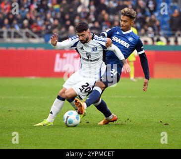 1. Dezember 2024, Baden-Württemberg, Karlsruhe: Fußball: Bundesliga 2, Karlsruher SC - Hamburger SV, Spieltag 14, BBBank Wildpark. Karlsruher Bambase Conte (r) und Hamburgs Marco Richter kämpfen um den Ball. Foto: Uli Deck/dpa - WICHTIGER HINWEIS: Gemäß den Vorschriften der DFL Deutschen Fußball-Liga und des DFB Deutschen Fußball-Bundes ist es verboten, im Stadion und/oder im Spiel aufgenommene Fotografien in Form von sequenziellen Bildern und/oder videoähnlichen Fotoserien zu verwenden oder zu nutzen. Stockfoto