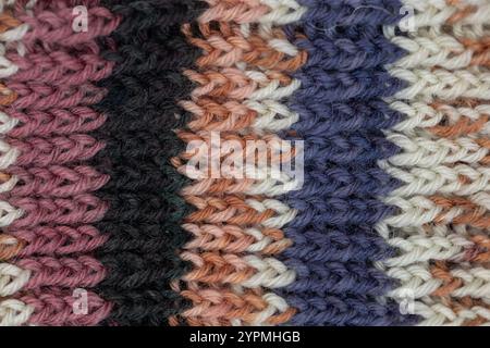 Handgefertigte Strickstruktur mit Wolle in den Farben Blau, Braun, Pink und weiß. Stockfoto