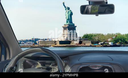 Blick durch die Windschutzscheibe des Autos mit Blick auf die Freiheitsstatue, ein Wahrzeichen auf Liberty Island im New York Harbor, USA Stockfoto
