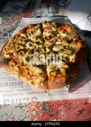 Pizza mit gelbem Käse und Gemüse auf der Pizza Stockfoto