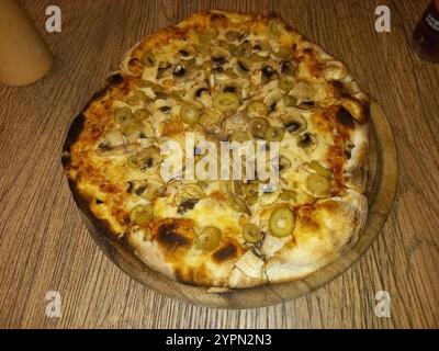 Pizza mit gelbem Käse und Gemüse auf der Pizza Stockfoto