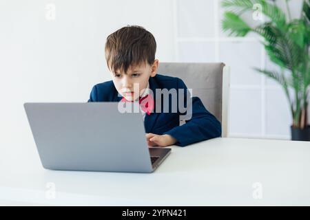 Junge Im Business-Anzug, Der Auf Laptop Spielt Stockfoto