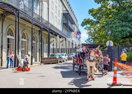 New Orleans, LA, USA - 16. Oktober 2021: Straßenszene im French Quarter mit Royal Orleans Hotel, Touristen, Maultieren und Kutschen und Arbeitern an einem sonnigen Tag Stockfoto