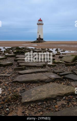 Point of Ayr Lighthouse bei Ebbe am Talacre Beach mit Felsen im Vordergrund, aufgenommen am 30. Oktober 2024. Stockfoto