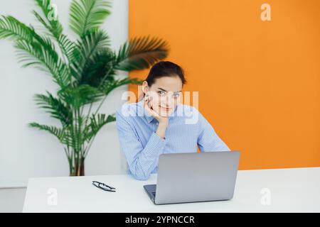 Geschäftsfrau, die im Büro am Schreibtisch spricht, lernt, online über Laptop zu sprechen Stockfoto