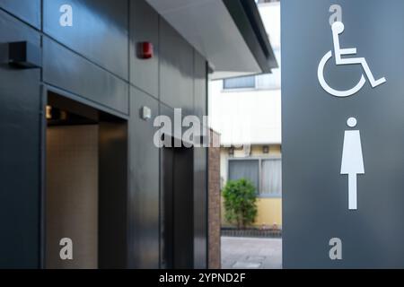 Weibliche und behinderte Toilette in Japan. Öffentliche Toiletten für Frauen und Behinderte, Toiletten-Schild und unscharfe offene Türen Stockfoto