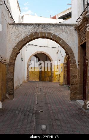 Charmanter Bogengang im Habous-Viertel von Casablanca, Marokko, mit traditioneller marokkanischer Architektur mit Steinbogen und Topfpflanzen. Stockfoto