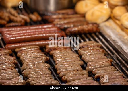 Nürnberger Christkindlesmarkt, 01.12.2024 Nahaufnahme von Nürnberger Rostbratwürsten, die auf einem Grill zubereitet werden. Im Hintergrund sind Brötchen Weggla zu sehen, die typisch für das Servieren der Bratwürste auf dem Nürnberger Christkindlesmarkt sind. Die Szene zeigt die kulinarischen Spezialitäten des Weihnachtsmarktes. Nürnberg Bayern Deutschland *** Nürnberger Weihnachtsmarkt, 01 12 2024 Nahaufnahme Nürnberger Bratwürste werden auf einem Grill zubereitet im Hintergrund sehen Sie Weggla Brötchen, die typisch für das Servieren von Würsten auf dem Nürnberger Weihnachtsmarkt sind Stockfoto