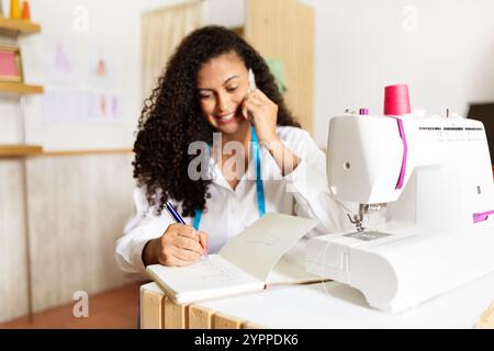 Kreative Designer engagierte sich bei der Arbeit, während sie im Studio telefonierten Stockfoto
